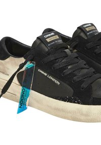 Sneaker in suede nera con accenti in pelle, dettagli strutturati, lacci piatti e una suola bianca invecchiata. Presenta il marchio sulla linguetta e sul lato.