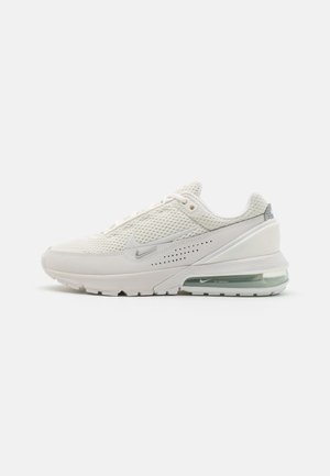 Sneakers Nike Air Max w off-white siateczce z srebrnymi akcentami, z poduszką powietrzną w pięcie i teksturowaną gumową podeszwą. Minimalistyczny design z perforacjami.