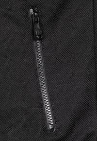 Fekete, texturált szövet függőleges műanyag cipzárral, amelyen egy Union Jack mintával domborított húzófül található.