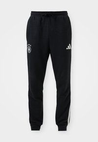 Sorte atletiske sweatpants lavet af blødt materiale. Har en snøre i taljen, hvidt Adidas-logo og sort-hvide side-striber.