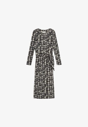 Zwarte langmouw jurk met een taille die is getailleerd, met een witte cirkelvormige en geometrische print overal. Gemaakt van zachte, lichte stof.