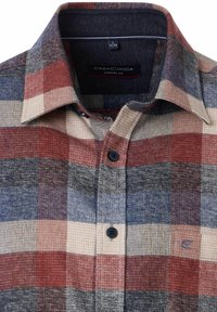 Koszula na guziki w kratę w kolorach czerwonym, niebieskim i kremowym. Materiał o teksturze, w casualowym kroju, z kołnierzykiem i ciemnymi guzikami. Z tyłu przy kołnierzu widoczna metka marki.