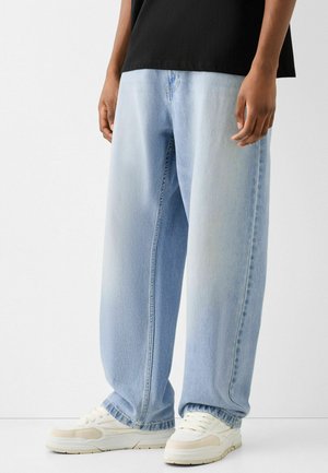 Valkoiset farkut vaaleansinistyysillä, rentoa istuvuutta, suorat lahkeet ja hienovaraista haalistumista. Yhdistettynä valkoisiin lenkkareihin ja mustaan paita.