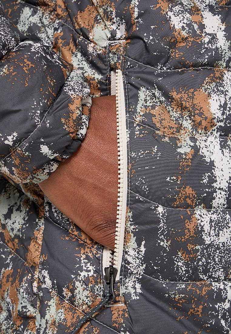 Kurtka puchowa w czarno-brązowo-zielony wzór w plamy, z boczną kieszenią na zamek i pikowaną teksturą.