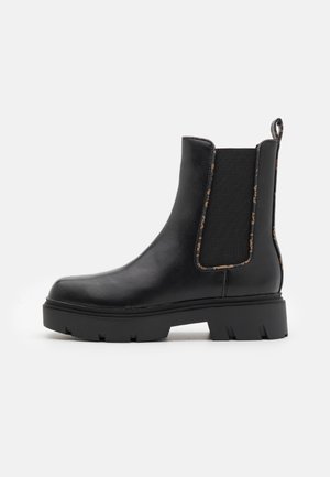 Stivale Chelsea nero alla caviglia in pelle liscia con pannelli laterali elasticizzati, suola spessa e linguetta sul retro per un facile indosso.