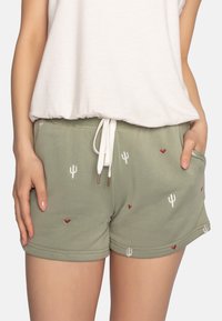 Groene katoenen shorts met witte trekkoord, versierd met geborduurde cactussen en rode harten. Zachte textuur en een ontspannen pasvorm met zijzakken.