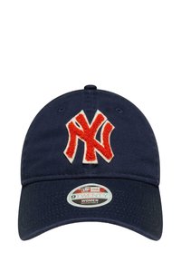 Navy blue cap with a curved brim, featuring a white and orange embroidered logo. Adjustable strap at the back, cotton material.