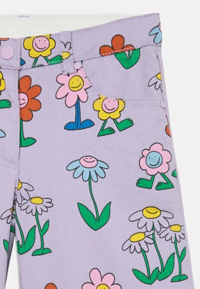 Lila denimtyg med färgglada blommönster och leende ansikten. Designen innehåller olika blomformer och gröna stjälkar.