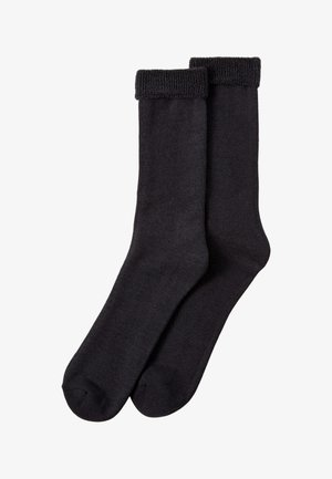 Paire de chaussettes noires unies avec revers pliés, présentées à plat sur fond blanc.
