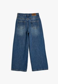 Jeans de mezclilla azul de pierna ancha con un lavado claro, que cuentan con dos bolsillos traseros y una etiqueta marrón en la cinturilla. Diseño simple de corte recto.
