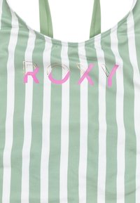 Randig linne i grönt och vitt, med rosa och guld "ROXY"-text. Mjuk tyg med slät yta och justerbara axelband.