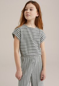 Črtasta bombažna majica v črni in beli barvi, s kratkimi rokavi in sproščenim krojem. V kompletu z usklajenimi črtastimi hlačami v istem barvnem vzorcu.