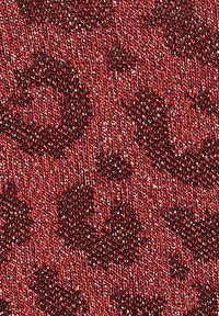 Tessuto rosso testurizzato con un motivo sottile e lucide rifiniture metalliche, creando profondità su uno sfondo lavorato a maglia.