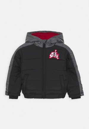Chaqueta negra tipo puffer con acentos grises, capucha, cremallera frontal y bolsillos laterales. Cuenta con un interior rojo y un logo rojo y blanco en el pecho.