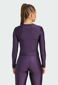 Long-sleeve purple metallic top with a fitted design, paired with matching leggings. Smooth texture and seamless construction.