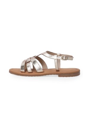 Metallisch goldene Sandalen mit überkreuzten Riemen, einer Schnallenöffnung und einer flachen, hellbraunen Sohle, mit einer glatten Textur und offenem Design.