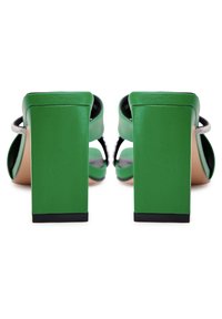 Sandales à talons hauts vertes avec talons épais larges, bouts ouverts et fines lanières ornées de strass, vues de dos.