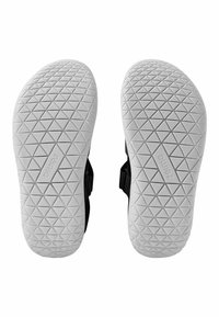 Svarta sandaler med en vit gummisula som har ett geometriskt mönster. Justerbara remmar på sidorna för en säker passform.