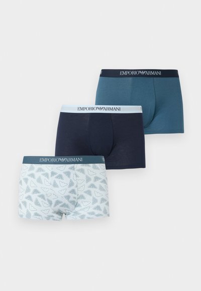 Trzy pary męskich bokserek w kolorach teal, granatowym i białym z szarymi wzorami logo, każda z paskiem w talii Emporio Armani.