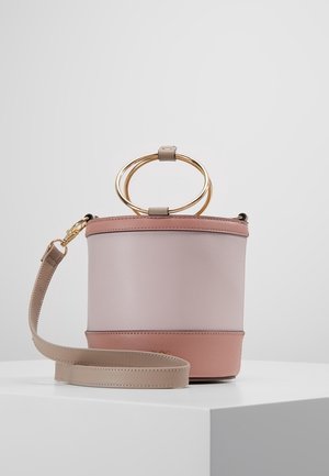 Kleine tweekleurige roze emmerhandtas met gouden dubbele ringhandvat en afneembare beige schouderriem op een witte ondergrond.