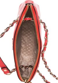 Červená kožená kabelka na rameno se zlatým zipem, řetízkovým popruhem a béžovým vzorovaným látkovým podšívkou.