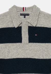 Suéter de malha cinza e azul marinho riscado, com colarinho canelado e pequeno logotipo da Tommy Hilfiger no peito.