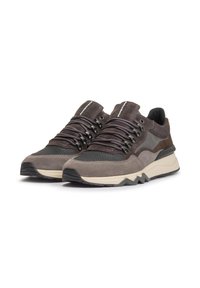 Sneaker grigi e marroni realizzati in pelle scamosciata e materiali in rete, con una spessa suola bianco sporco, lacci prominenti e dettagli testurizzati.