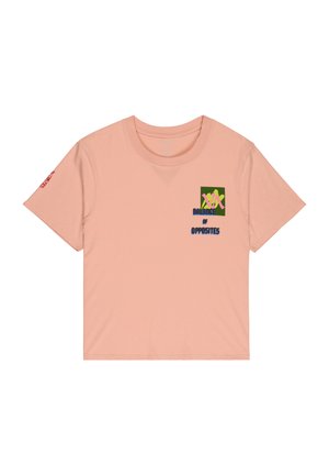 Svijetlo ružičasta majica kratkih rukava sa zelenom i žutom grafikom i tekstom "Balance of Opposites" na prsima te crvenim tekstom na lijevom rukavu.