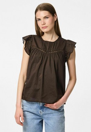 Blusa senza maniche marrone con spalle arricciate, caratterizzata da delicati ricami e dettagli arricciati lungo il seno. Indossata con jeans azzurri.