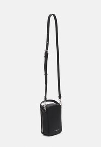 Borsa a tracolla nera con forma rettangolare, realizzata in tessuto. Presenta una cerniera argentata e una tracolla rimovibile per lunghezza regolabile.