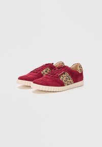 Red suede sneakers with leopard print side panels, textured rubber soles, and laces, featuring a round toe and low profile design.