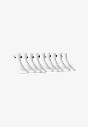 Zehn Paare weiße Knöchelsocken mit schwarzem Logo auf den gerippten Bündchen, in einer Reihe auf weißem Hintergrund ausgerichtet.