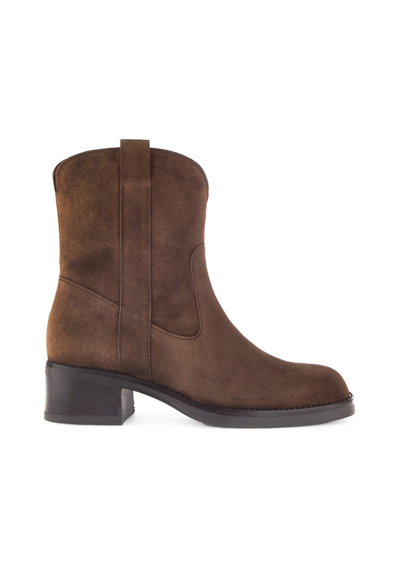 Botte cheville en suede marron avec un bout arrondi, des panneaux latéraux élastiques et un petit talon carré, présentant une texture lisse et un design simple.