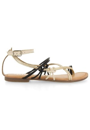 Sandal plat avec semelle marron, bride de cheville dorée avec boucle et boucles décoratives noires et beiges à travers le pied.