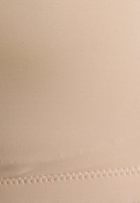 Μπεζ ριγωτό ύφασμα, λεία υφή, με ραφή ζιγκ-ζαγκ στην κάτω άκρη. Χωρίς ορατά σχέδια ή επιπλέον λεπτομέρειες.