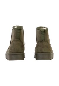 Bottines en daim vert avec intérieur doux, panneaux latéraux élastiques et languette arrière, dotées d'une semelle en caoutchouc plate et texturée.