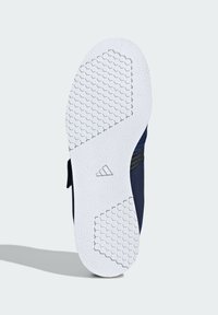 Navy tenisky mají podešev z bílé gumy s hexagonálním vzorem pro lepší přilnavost a logem umístěným blízko paty.