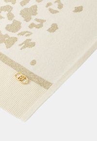 Scarf crema con stampa leopardata dorata e bordo luccicante, caratterizzata da una texture a coste e un logo in metallo dorato su un lato.