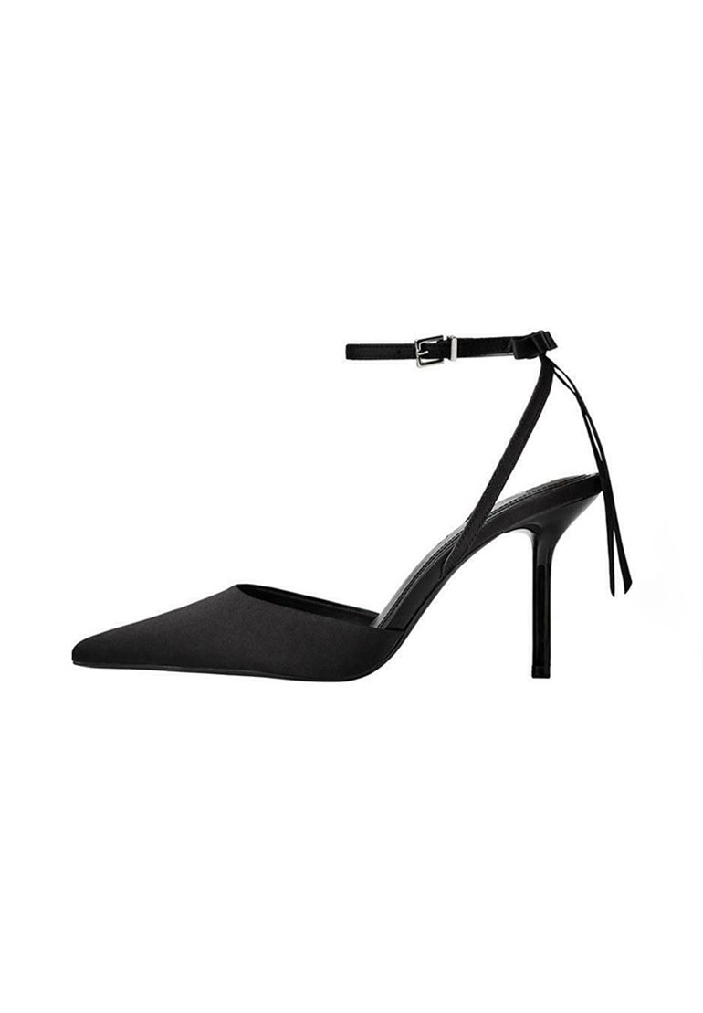 Pump nera con tacco alto, punta affusolata, finitura in satin, cinturino alla caviglia con fibbia e tacco sottile. La vista laterale mette in mostra il design elegante.