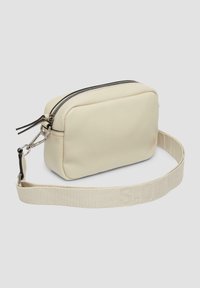 Torebka z syntetycznej skóry w kolorze kremowym, z zamknięciem na zamek błyskawiczny, o prostokątnym kształcie i materiałowym pasku z wytłoczonym tekstem. Srebrne akcenty metalowe.