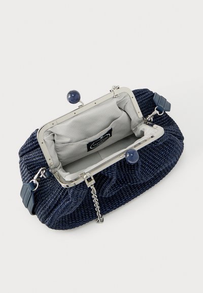 Τσάντα χειρός από ύφασμα σε ναυτικό μπλε με ασημένια μεταλλική κούμπωμα, στρογγυλούς μπλε κόμβους, αποσπώμενο αλυσίδα ιμάντα και εσωτερική επένδυση από ανοιχτό γκρι υφασμάτινη ρίγα με τσέπη.