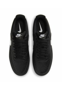 Sneakers Nike neri con tomaia in pelle liscia, dotati di una punta perforata, logo swoosh bianco e lacci neri.