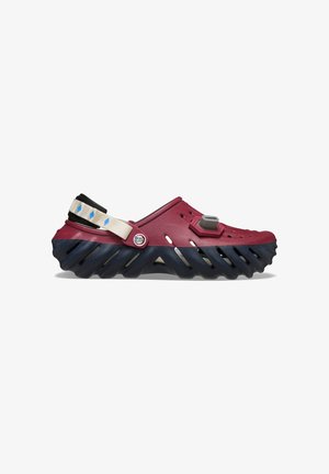 Slip-on klipklapper med maroon overdel, sort sål med store sideskæringer, justerbar beige rem og en knap med "Demon Slayer" tekst.