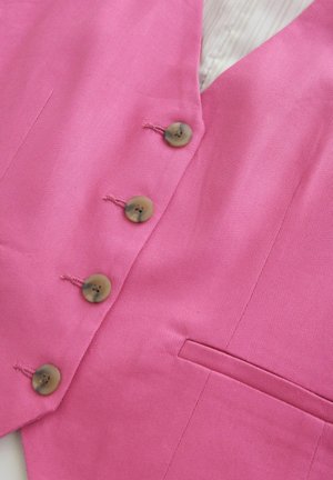 Pink vest with a textured fabric, featuring four rounded buttons and a side pocket. Inside has a striped lining for added detail.
