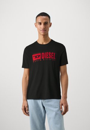 Čierne bavlnené tričko s veľkým červeným logom Diesel a nápisom "DENIM DIVISION". Klasický okrúhly výstrih a krátke rukávy, hladká textúra.