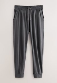Mørkegrå joggingbukser med elastisk talje, justerbar snøre, sidelommer og manchetter ved anklerne mod en lys baggrund.