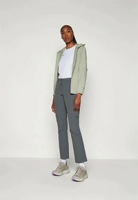 Light green hooded jacket, white t-shirt, gray pants, and beige sneakers. Smooth textures, functional design, and neutral colors.