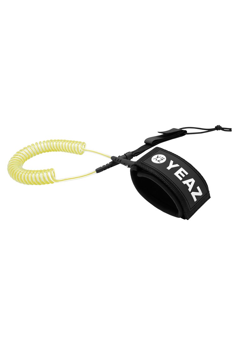Zwarte opgerolde leash met "YEAZ" logo, voorzien van een gevoerde enkelband en een flexibele gele kabel voor een veilige bevestiging aan een surfboard.