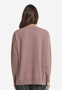 Ljust rosa tröja med avslappnad passform, med ribbade ärmslut och nederkant. Tillverkad av ett mjukt, strukturerat stickat material, designad för komfort.