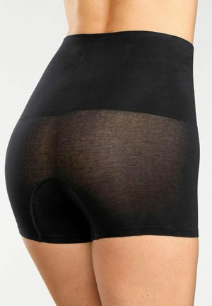 Person wearing high-waisted black seamless shorts with sheer fabric on the lower back and upper thigh areas.